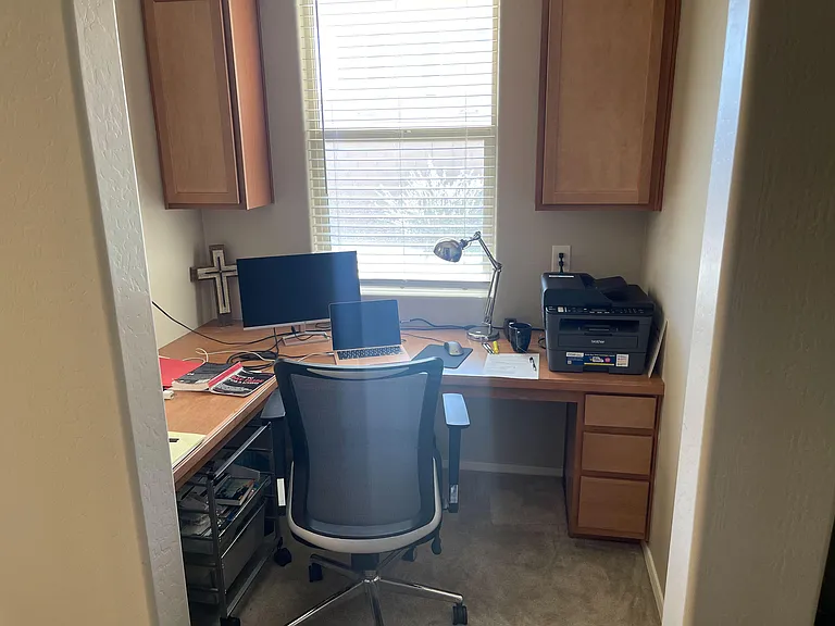 Compact built-in desk nook with overhead cabinets, task lighting, and a windowideal for remote work or study.