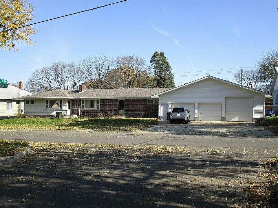 Brick section and garage behind the left garage door are bot