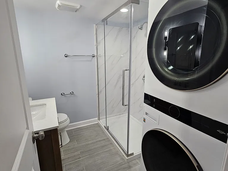 bathroom with stackable front loading washer and dryer