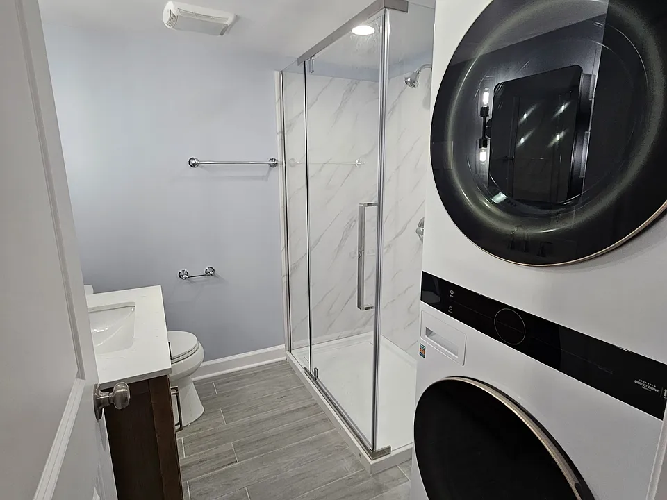 bathroom with stackable front loading washer and dryer