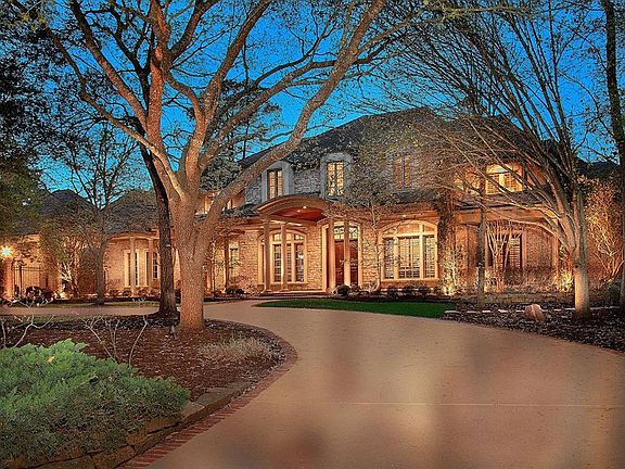 The well-lit front porch is the perfect place to take in the serene evening.