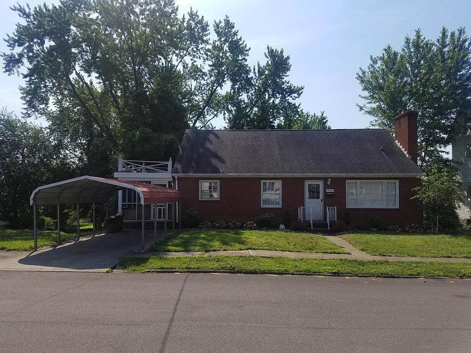 Front of house with a flower garden and parking