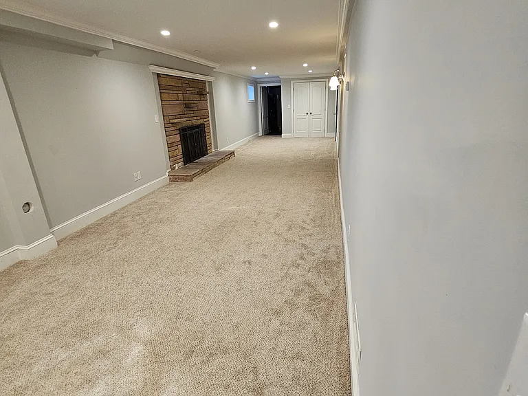 large, long living room area with fireplace and double door storage closet