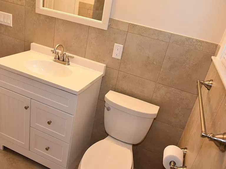 Bath: Kohler elongated toilet, Moen faucet, 3 compartment vanity, porcelain tile, towel rod, exhaust fan