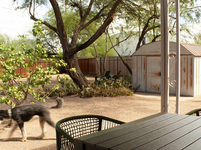 Covered patio with outdoor dining furniture and grill.