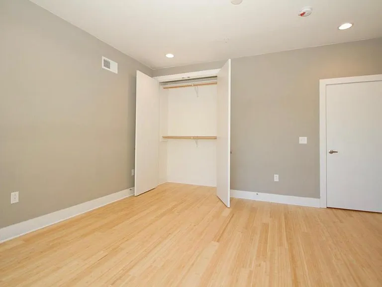 East bedroom with ample sunlight and plenty of storage