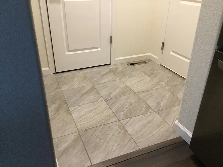 Tile area with coat closet at garage entry