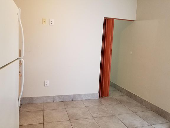 Living kitchen area leading to bedroom door