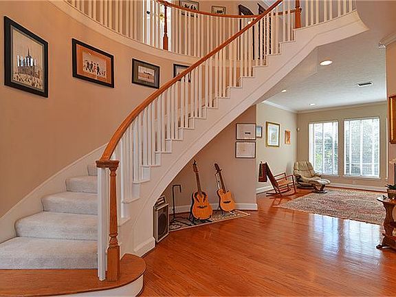 The entry has a grand feeling; high ceilings, sweeping curved staircase, and hardwood floors!!