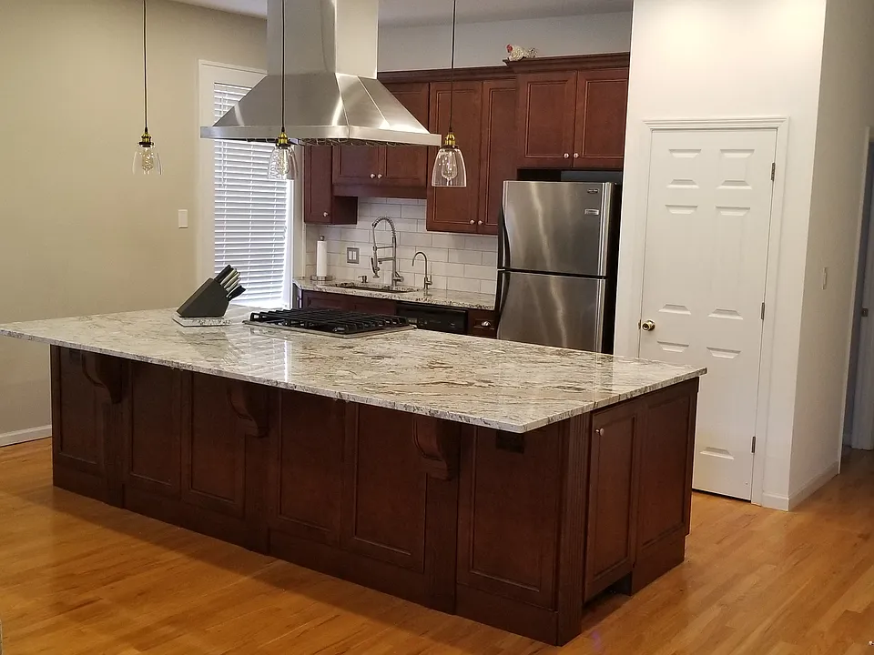 Kitchen with very large island that opens up to the living room. Perfect for hosting. Generous pantry to he right of fridge.