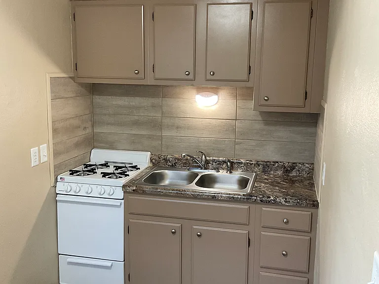 Freshly painted kitchen cabinets, New countertop, New stove, New tile backsplash, New sink & faucet!