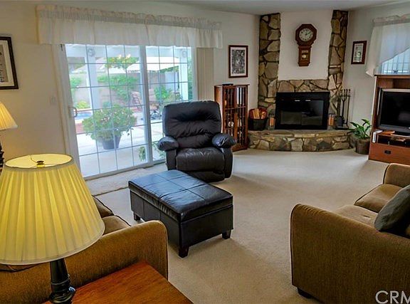 Step into the spacious living room with rock wood-burning fireplace and sliders inviting you to step