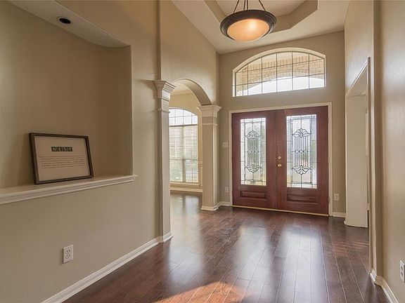 The front entry has beautiful double doors and a wide foyer with art niche.