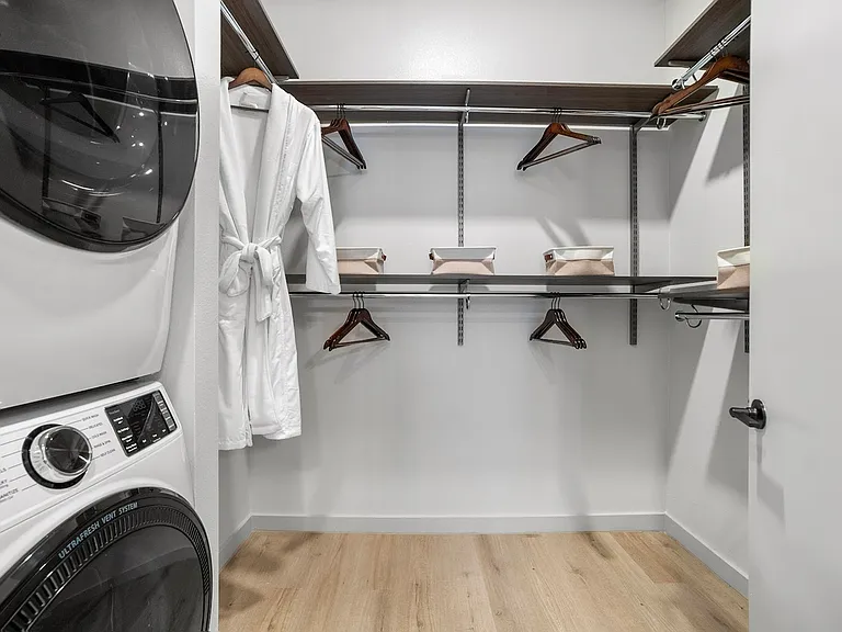 Experience upscale living with this chic walk-in closet and convenient laundry area. Experience upscale living with this chic walk-in closet and convenient laundry area.