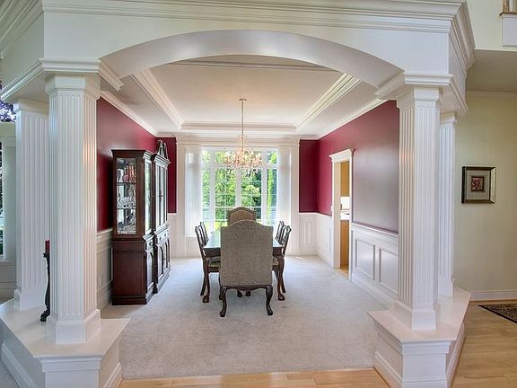 Formal dining room with pillars, custom millwork & paint and box beam ceiling