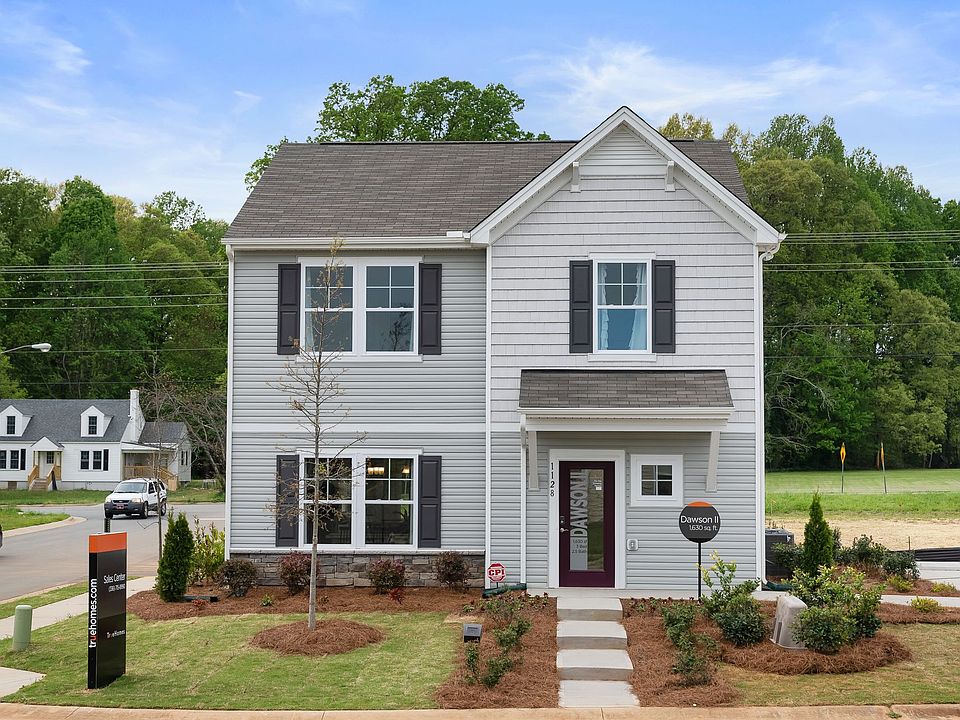 A white house with black shutters and a purple door is for sale.