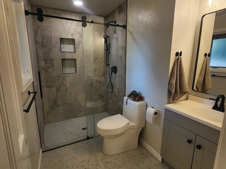 Primary bathroom with all new fixtures and surfaces, including curbless shower.