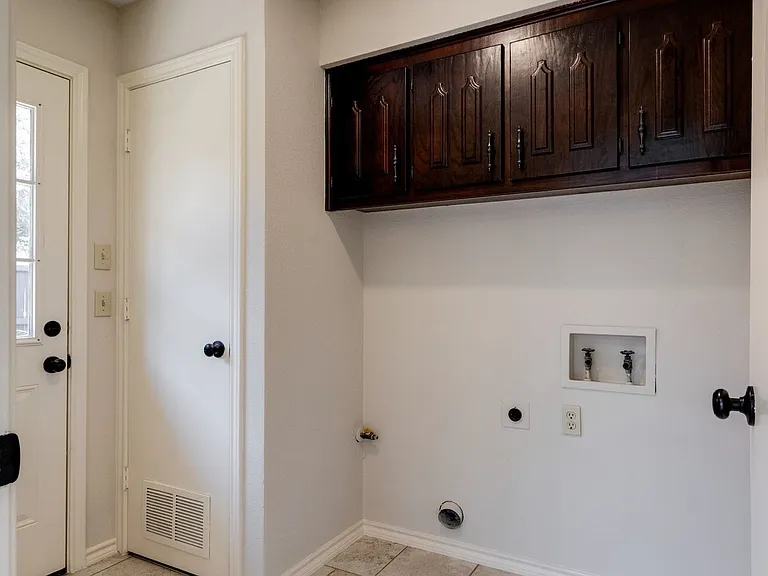 Laundry area has built in cabinets.