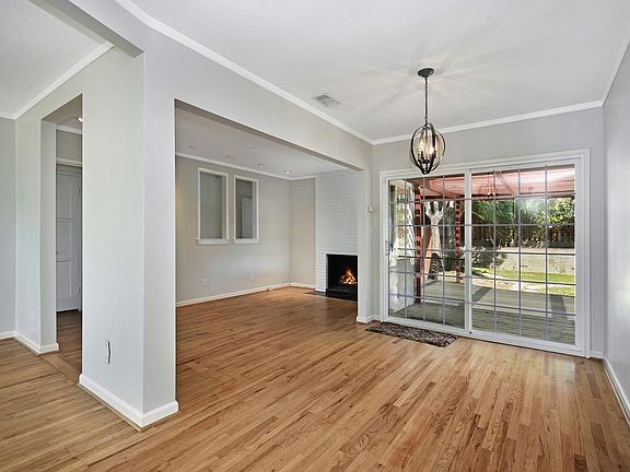 Looking across dining room into family room with lovely fireplace. Dual pane doors out to patio.