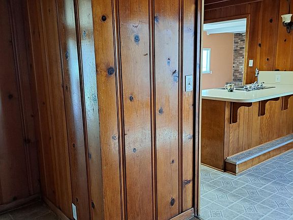 House has large living room with fireplace off the kitchen. Kitchen and adjacent large den area are Cedar walls. Kitchen has beautiful real wood cabinets throughout.