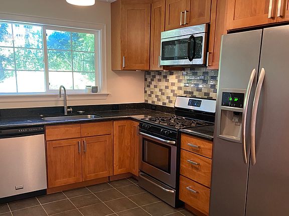 Remodeled kitchen with tile floors, granite countertops, stainless steel appliances, window over sink to look out to private backyard.