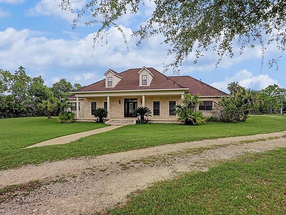 Beautiful stone home with front porch, leaded glass front door, private well fed sprinkler system, plus city utilities.