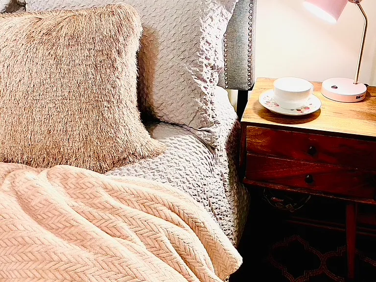 Cozy and Comfortable Queen Bed in bedroom, with bathroom adjacent.