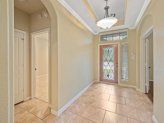 Beautiful entry with leaded glass door, inverted tray ceiling, and tile flooring.