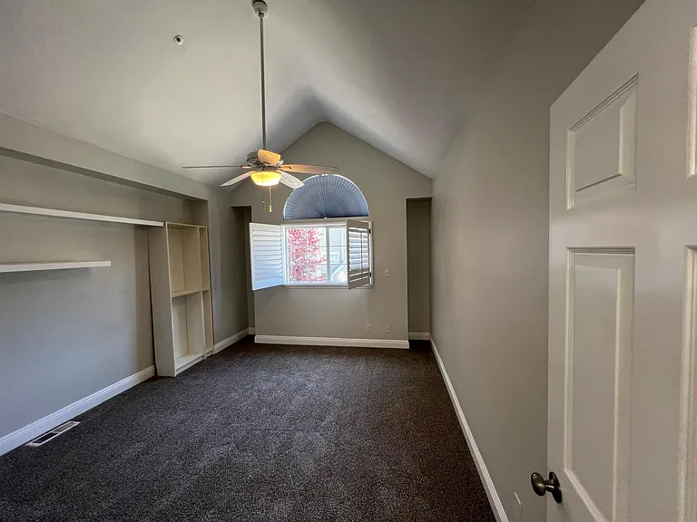 Upstairs bedroom with vaulted ceiling, built ins, shutters