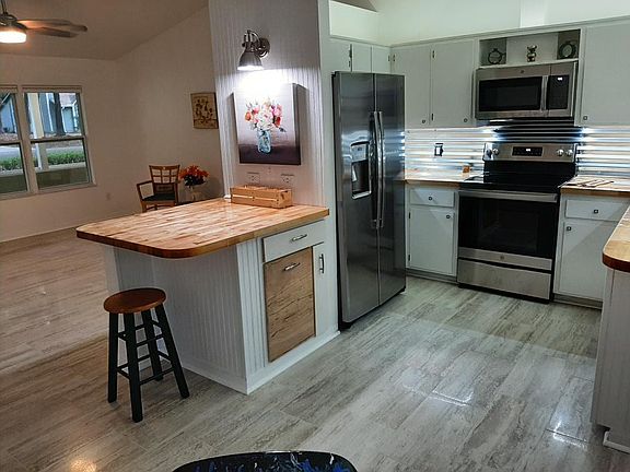 In dining area facing Breakfast Bar and Living Room. Kitchen has all new SS appliances; LED under and above counter lighting