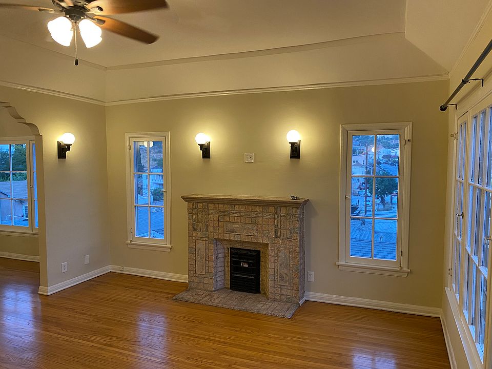LARGE FORMAL LIVING ROOM WITH RESTORED FAUX BATCHELDER FIREPLACE, VAULTED CEILINGS, VINTAGE SCONCES AND REDONE HARDWOOD FLOORS