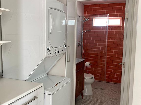 Designated laundry area. Washer and dryer unit. Bottom cabinet and folding area. Broom closet, pantry, and overhead storage.