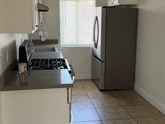 Kitchen with appliances - stainless steel stove and refrigerator