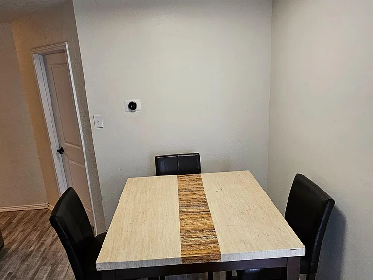 Dedicated dining nook with a four-seat table, durable flooring, and overhead lightingideal for everyday meals or work.