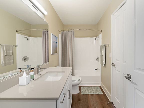 Renovated Package I bath with beige granite countertops, white cabinetry, and hard surface flooring