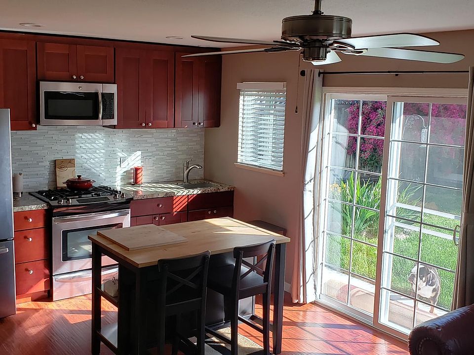 kitchen with table and 2 chairs with sliding door to backyard. The table and chairs stay in the unit.
