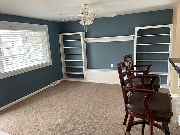 Main floor sitting room with bay window and built in shelving.