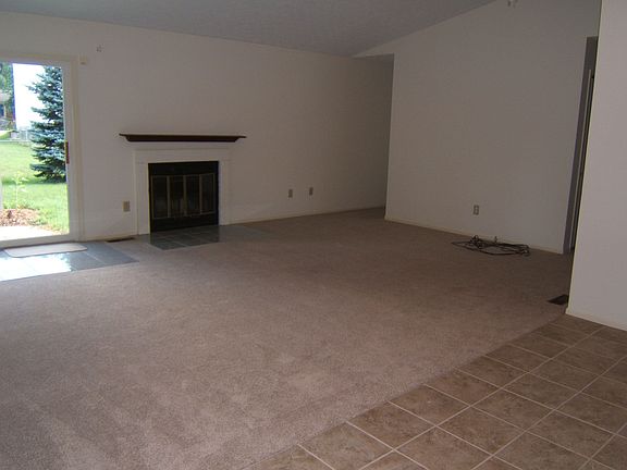 Great Room with slider to brick patio, vaulted ceiling with fan