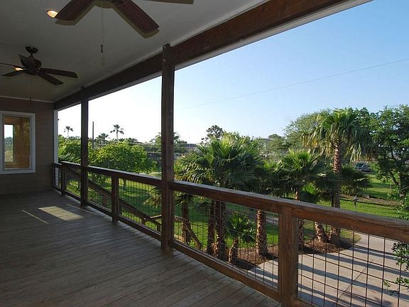 Oversized Covered Front Deck with Recessed Lighting and Outdoor Fans. Some Bay Views Between Front Houses and Over Trees.