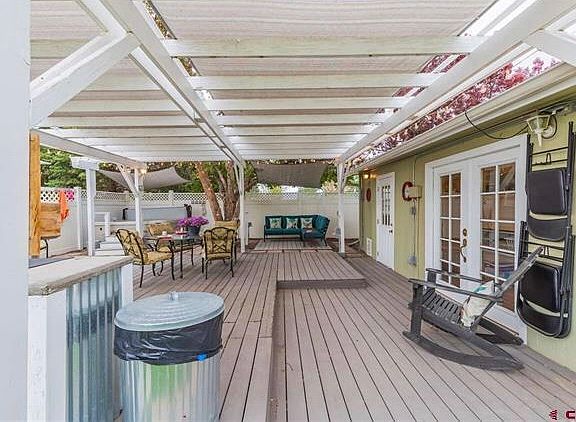 Porch with outdoor seating and grill. The single/double doors lead to the washer and dryer units, which are shared with the upstairs tenant.
