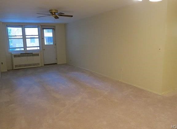 Living room with ceiling fan and door to balcony