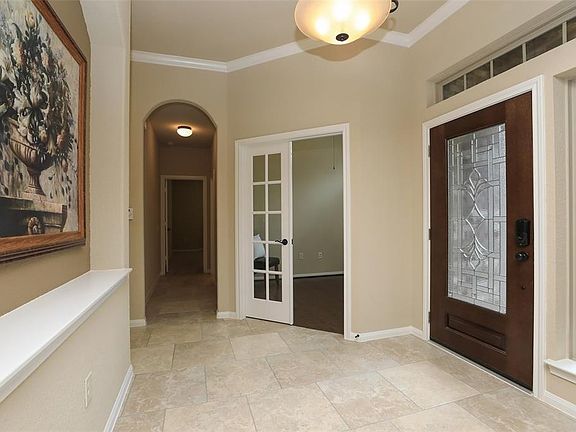 Lovely entry with upgraded tile flooring, high ceiling and crown molding