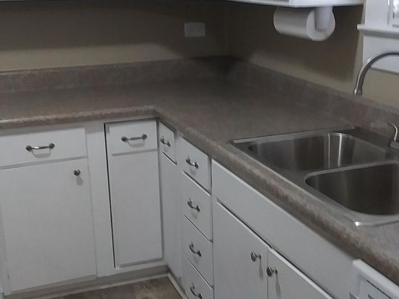 Kitchen leads to utility room at back and dining room. New refrigerator, stove, dishwasher, counters and sink