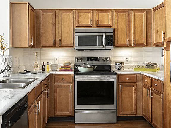 Apartment Kitchen with Stainless Steel Appliances, quartz counters and wood floors.