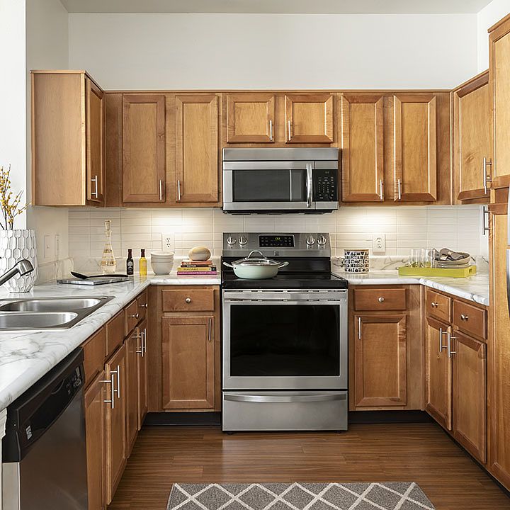 Apartment Kitchen with Stainless Steel Appliances, quartz counters and wood floors.