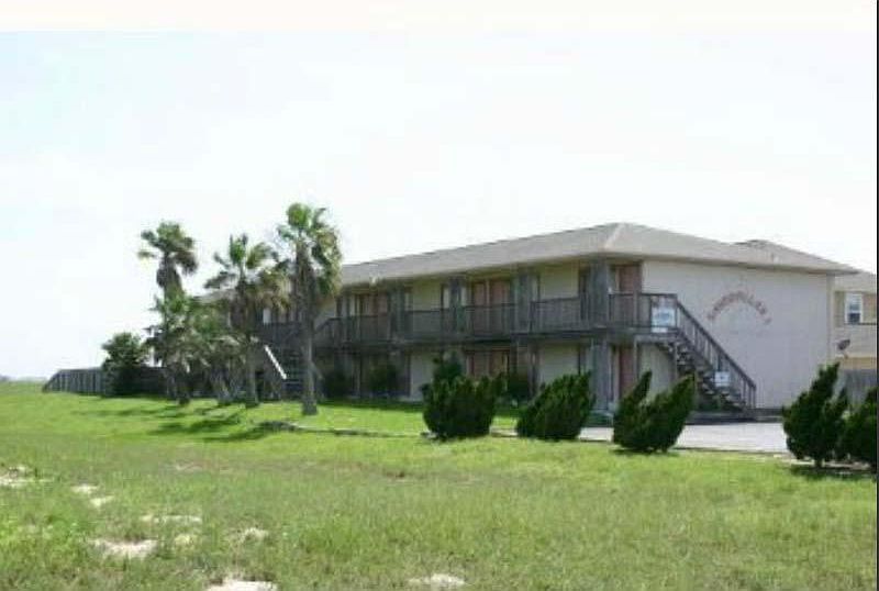 Smaller 18 unit condo complex with open space in front.