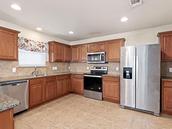 The kitchen features granite counters and plenty of cabinets for storage.