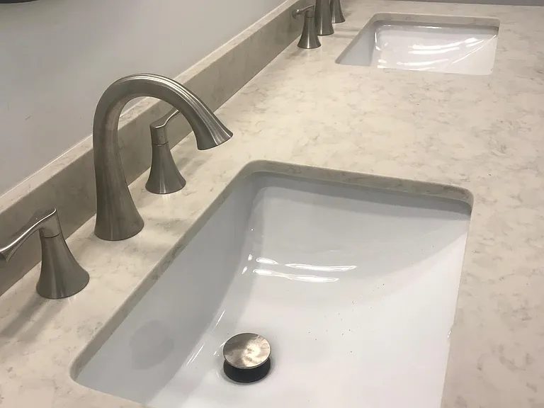 The double sink counter top is Quartz with brushed nickel fixtures.