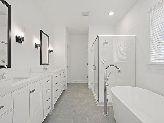 Primary bath with freestanding soaking tub and dual vanities