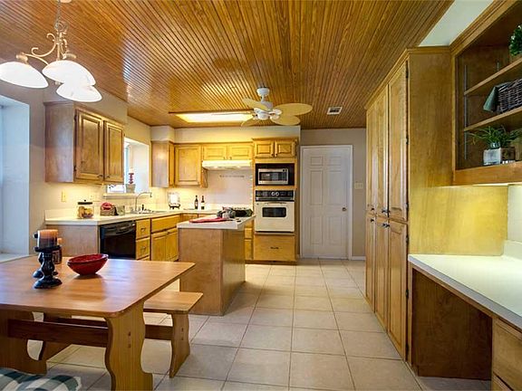 The unique stained bead board ceiling, ample cabinet space, a built-in desk area, and 14" tile floors combine to create a beautiful kitchen.